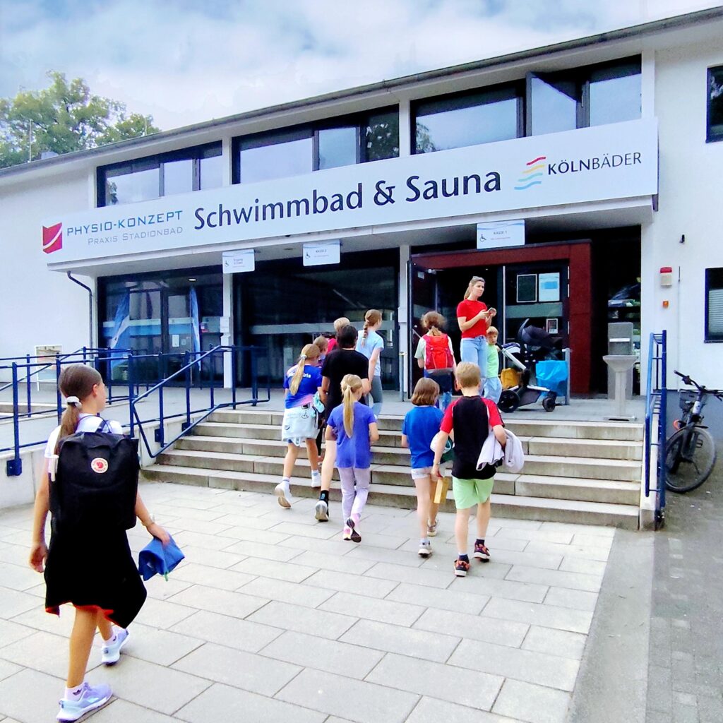 Eine Gruppe von Kindern geht beim MACH3 Feriencamp gemeinsam in das Kölner Stadionbad.