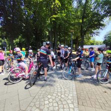 Ein Trainer erklärt einer Gruppe junger Radfahrer die nächste Übung beim MACH3 Feriencamp.